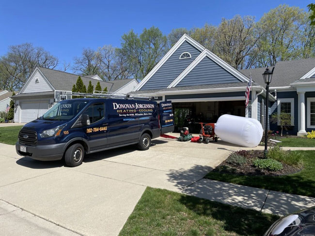 Donovan & Jorgenson Heating and Cooling van and tools outside a home in Mukwonago, WI